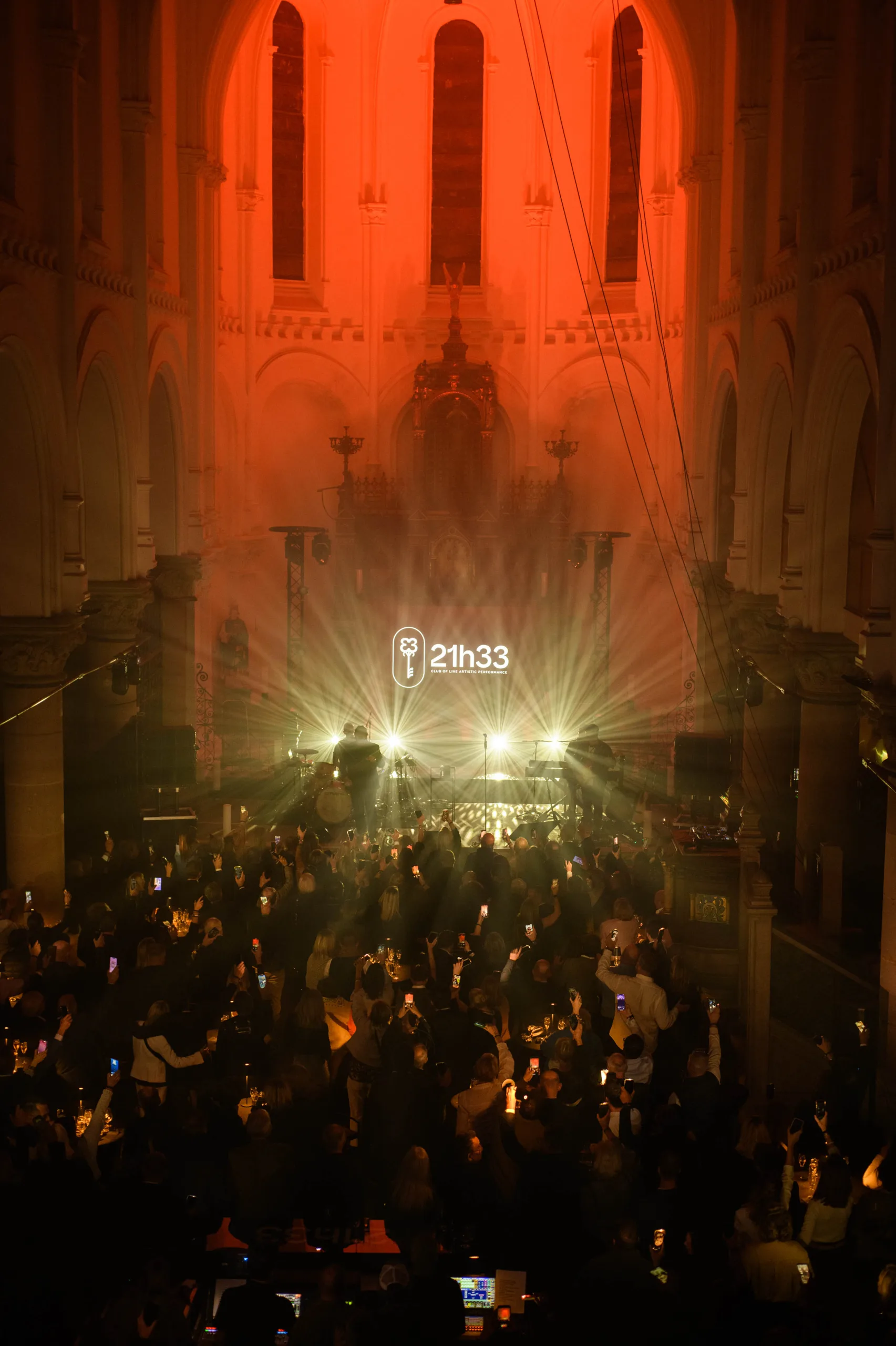 Nef baignée de lumière rouge et logo 21h33 — concert privé, Lille